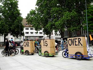 drei Fahrradanhänger hintereinander mit dem Schriftzug "Car is over"