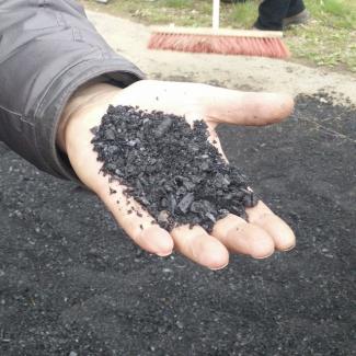 Die fertige Holzkohle wird auf einer Hand präsentiert