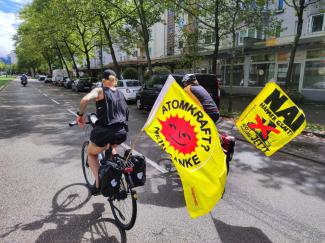 Menschen radeln mit gelbem Anti-Atom Banner auf einer Straße