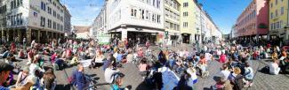 menschen sitzen auf dem Platz am Bertholtsbrunnen zum Sitzstreik