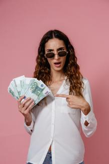 Photo by Pavel Danilyuk: https://www.pexels.com/photo/a-woman-in-white-long-sleeves-holding-money-8638317/