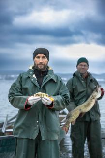 Zwei Generationen Fischer am Bodensee mit großem und kleinem Fisch